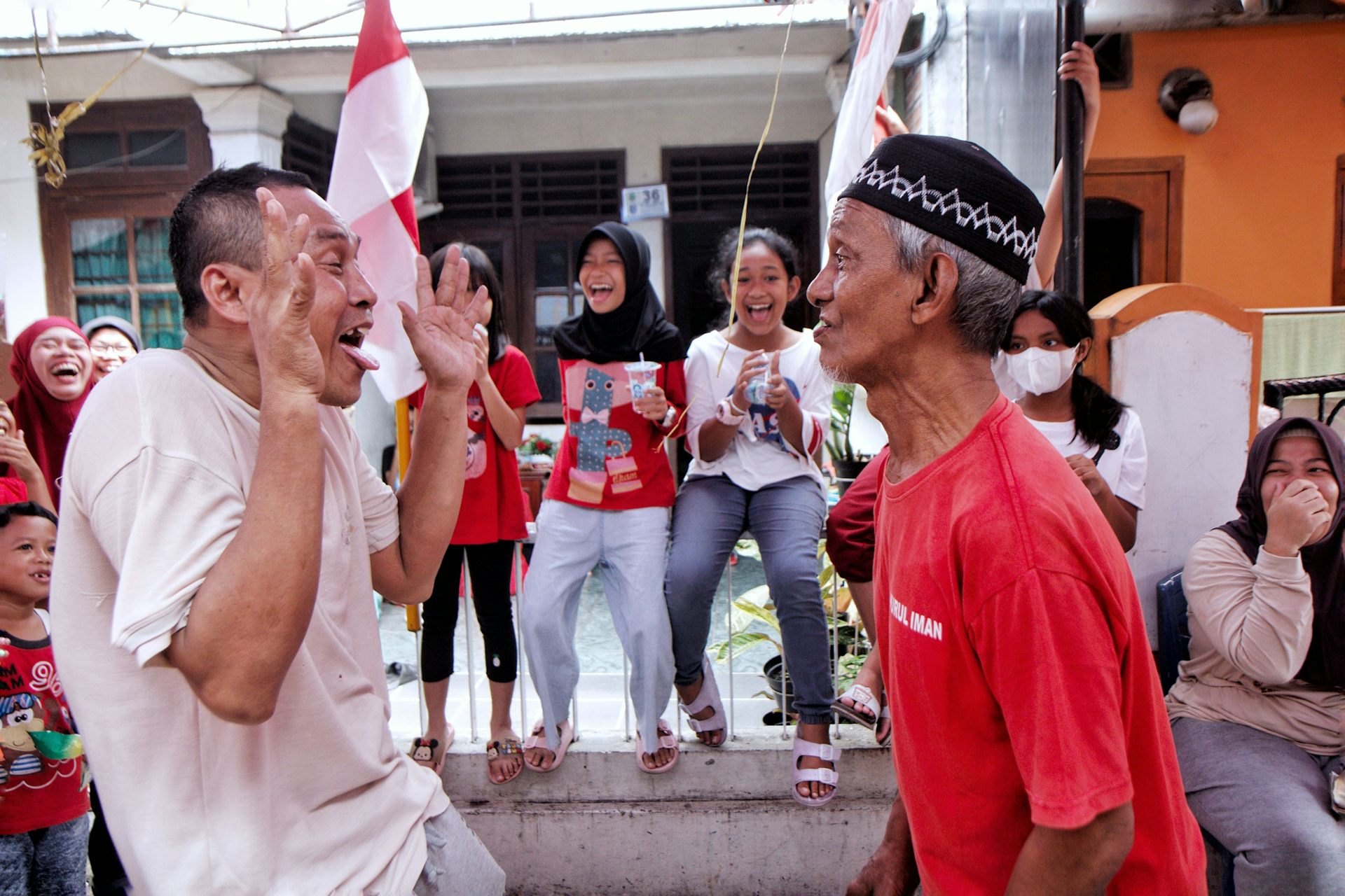 Dua pria mengikuti lomba perayaan 17 Agustus di lingkungan tempat tinggal.