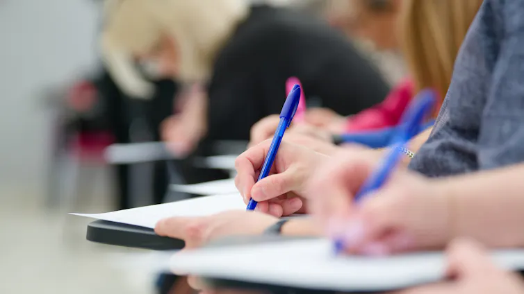 Hands writing in exam