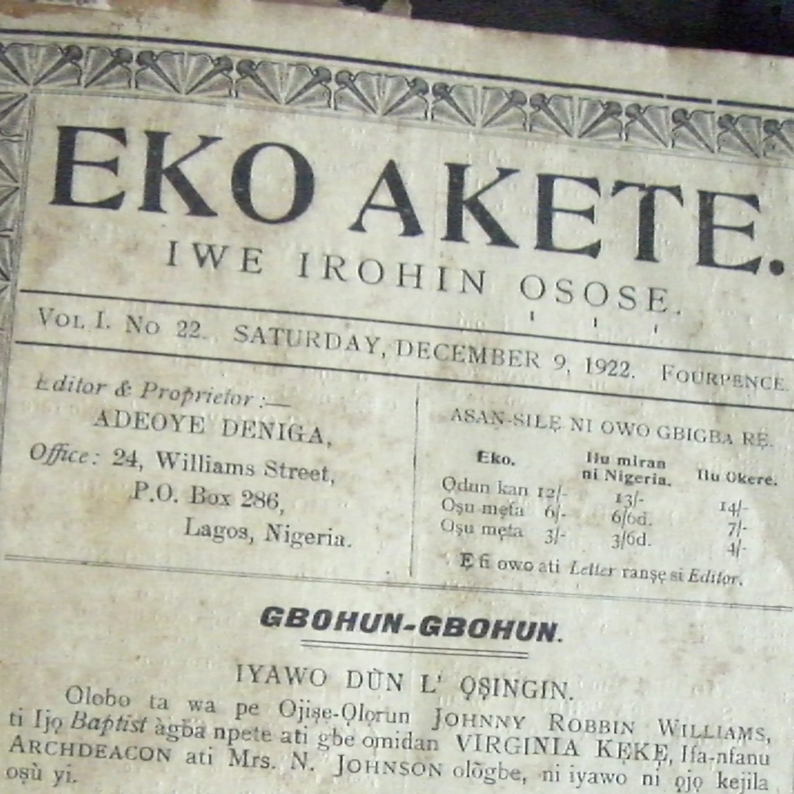 A black and white photo of a vintage newspaper with an ornate border, printed words and the title 'Eko Akete'.