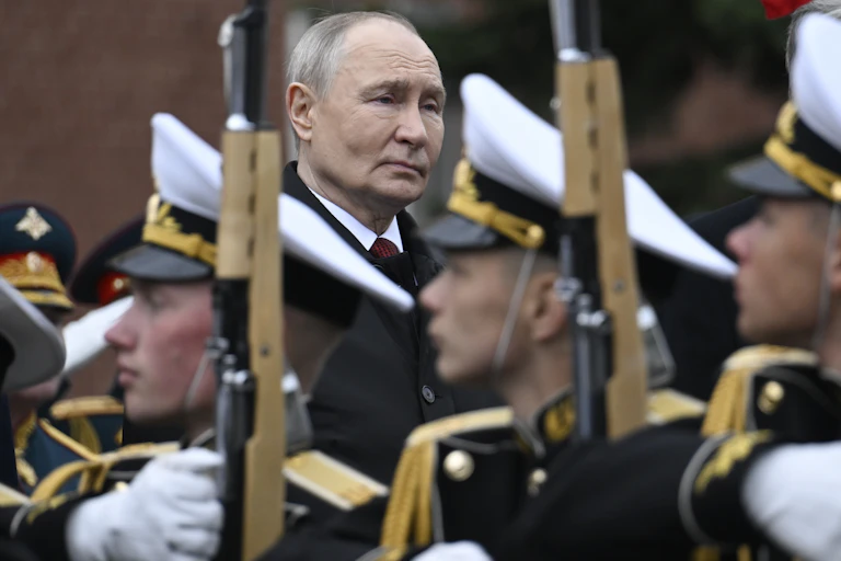 Russian president Vladimir Putin, stands behind an honour guard of Russian soldiers.