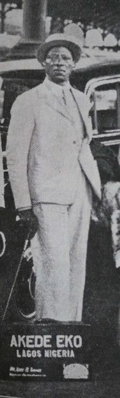 A vintage black and white photo of a dapper African man in suit and hat.