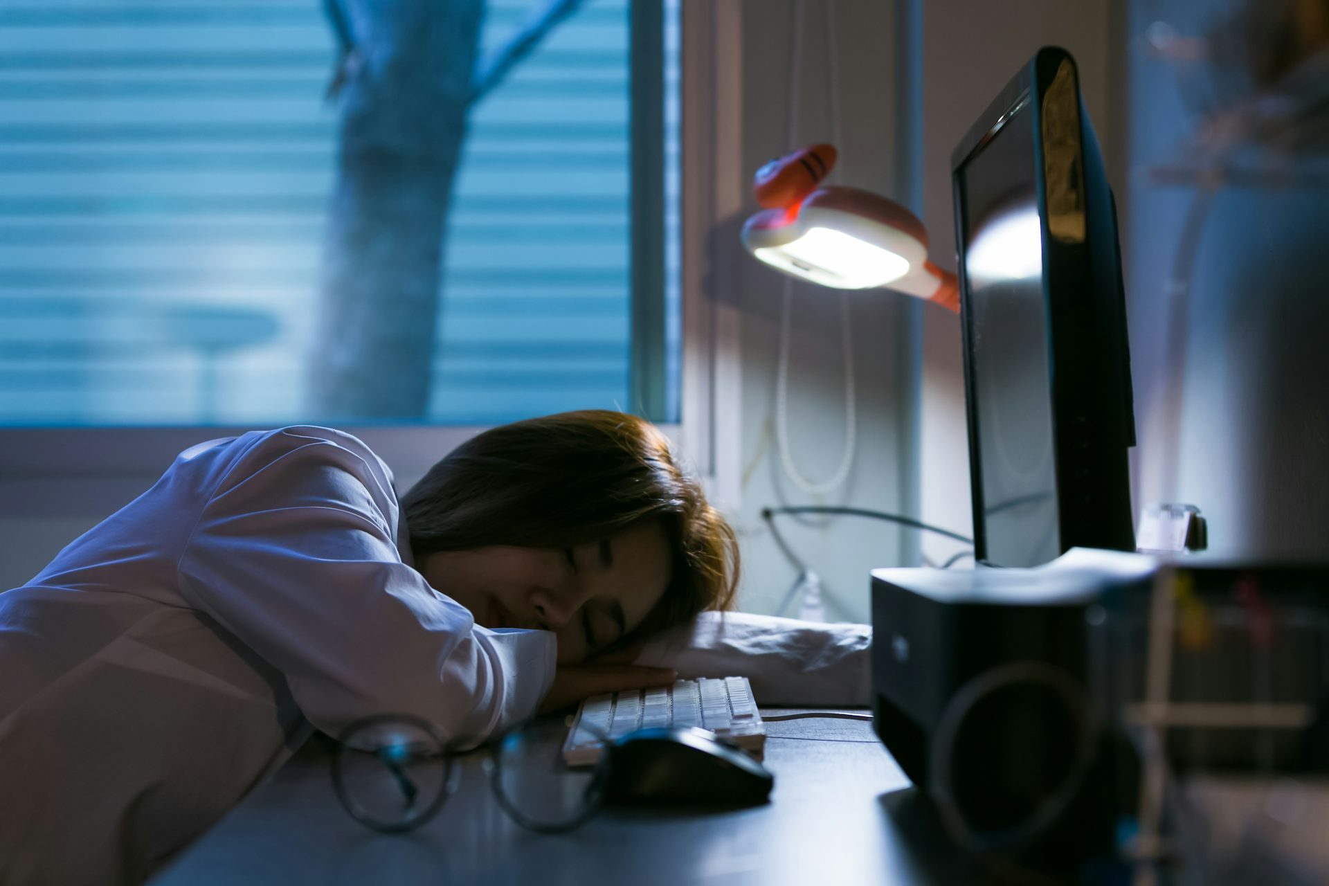 Exhausted student sleeping at desk at night