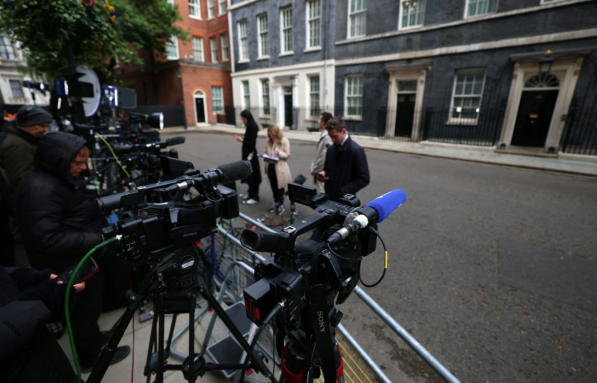 reporters prepare for broadcasts in front of 10 downing street.