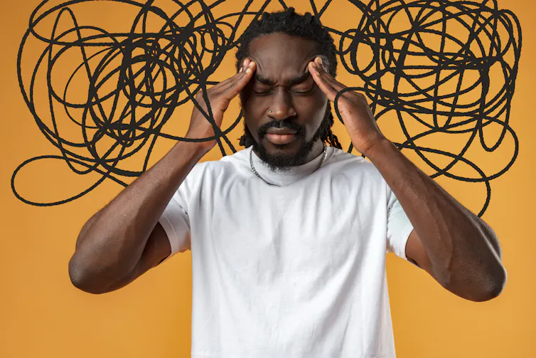 A man with a distressed expression, fingers to his temples, and drawn black squiggly lines around his head to indicate stress.