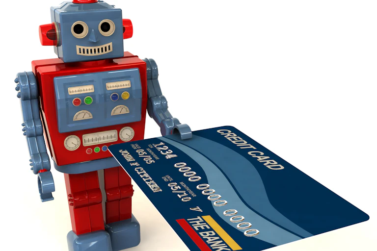 a toy robot holding out a credit card