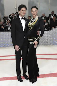 a man in a tux and woman in black dress pose for a photo