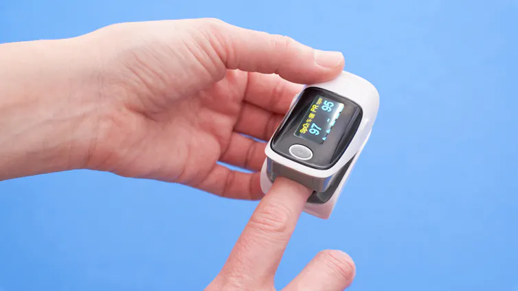 A pulse oximeter on a person's finger.