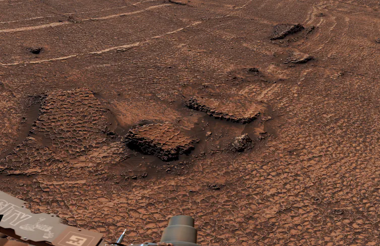 A photo of the Martian surface with polygon-shaped rock formations on the surface.