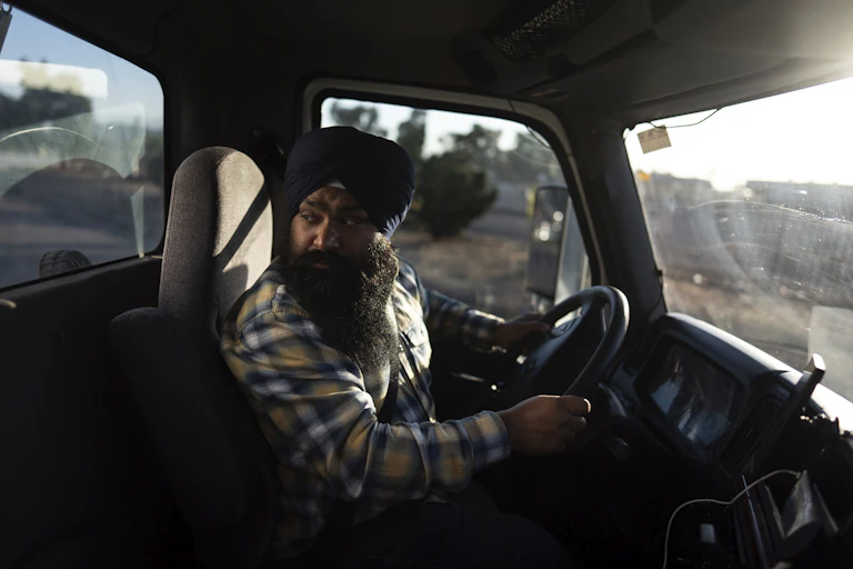 A sikh man in a turban in the cab of a truck