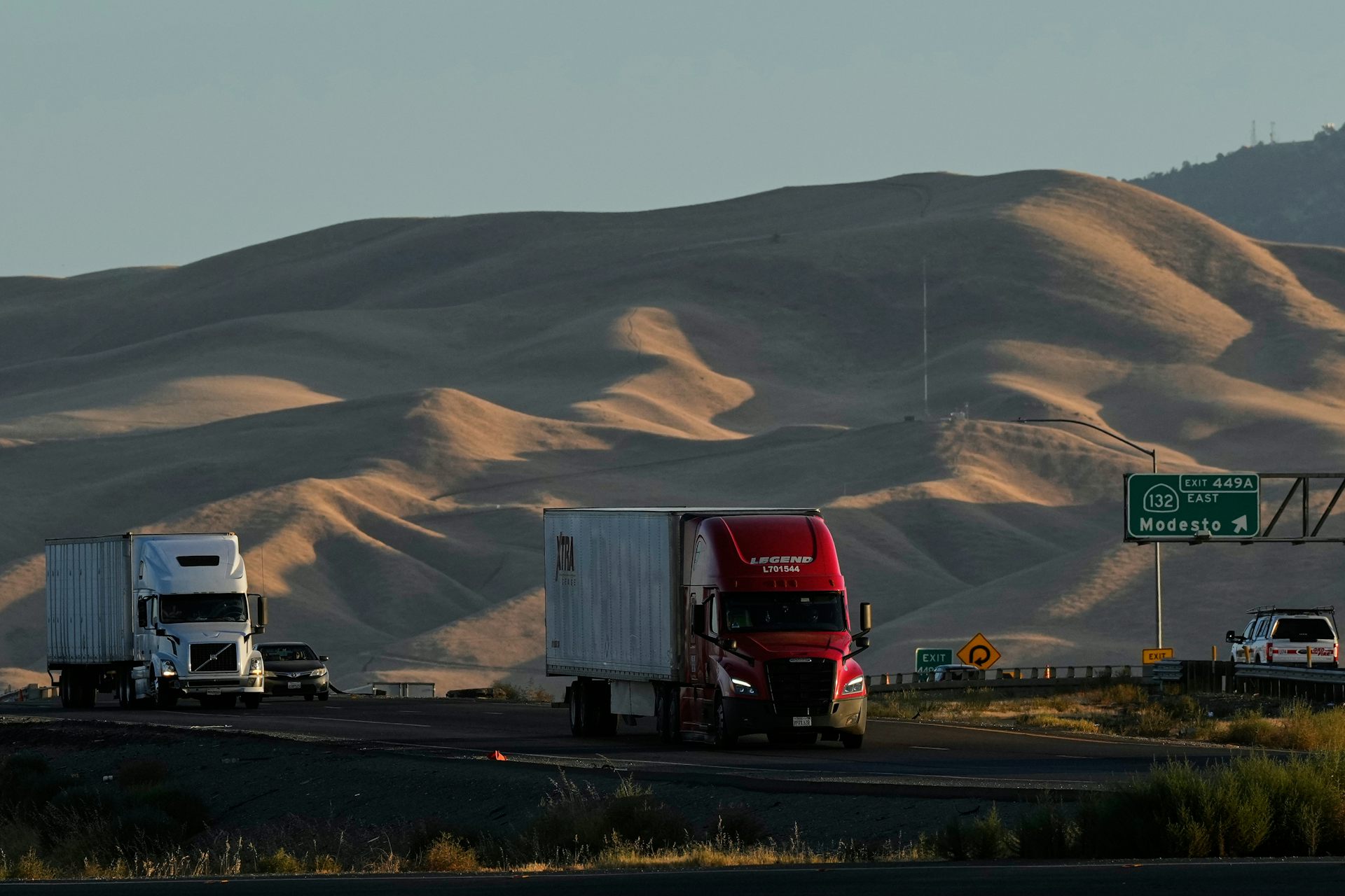 Freight trucks travel on a highway