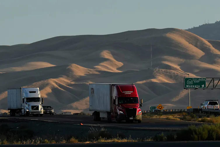 Freight trucks travel on a highway
