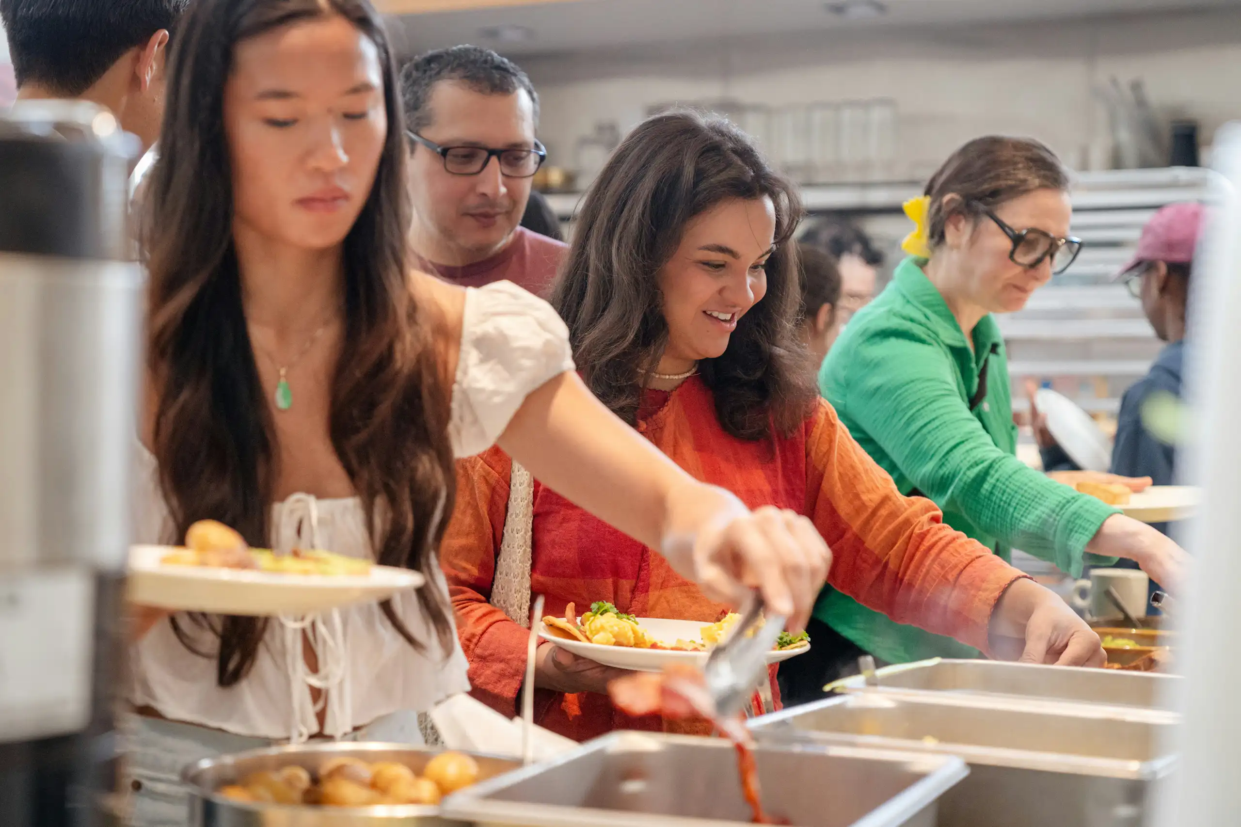 Young people in casual clothes serving themselves at a cafeteria