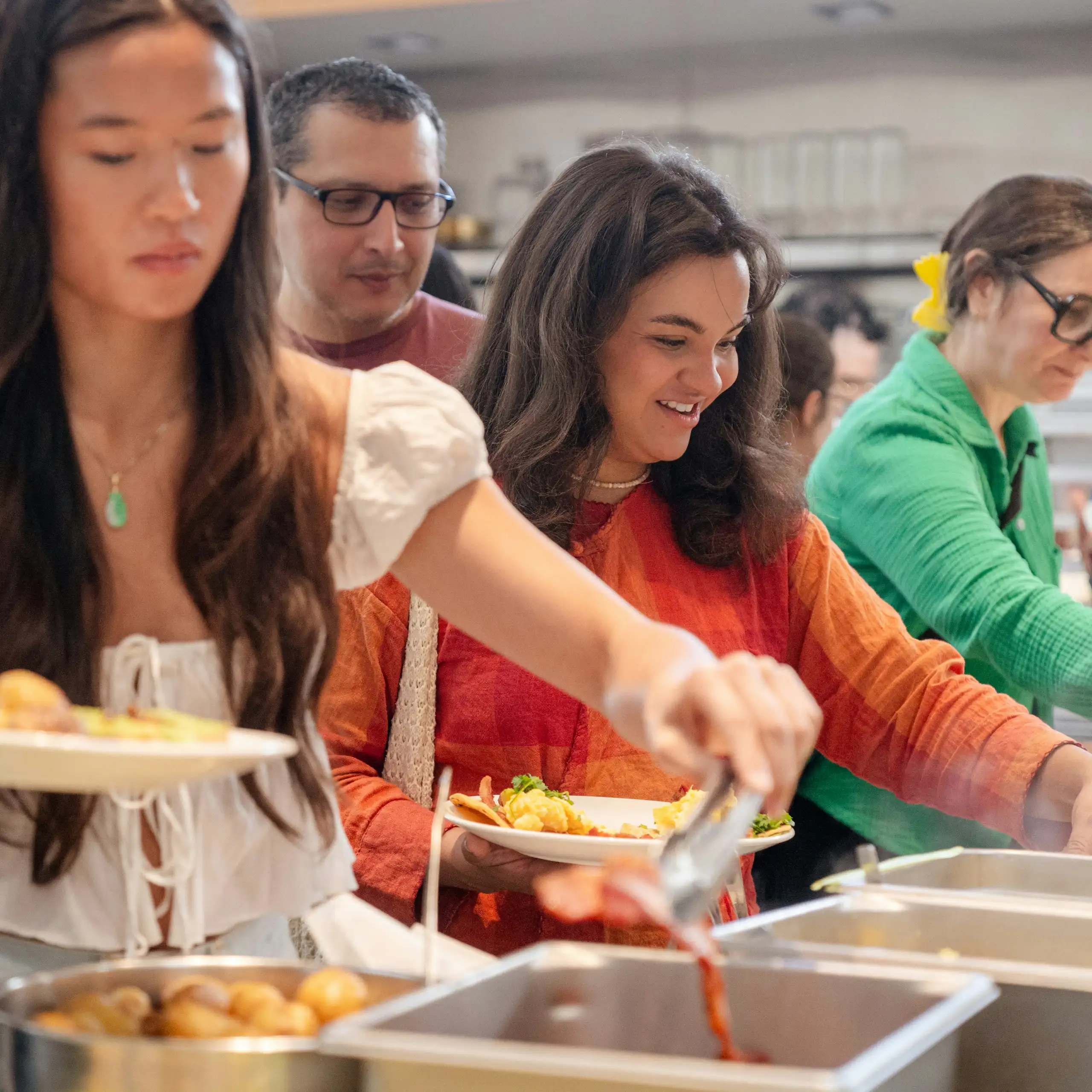 Young people in casual clothes serving themselves at a cafeteria