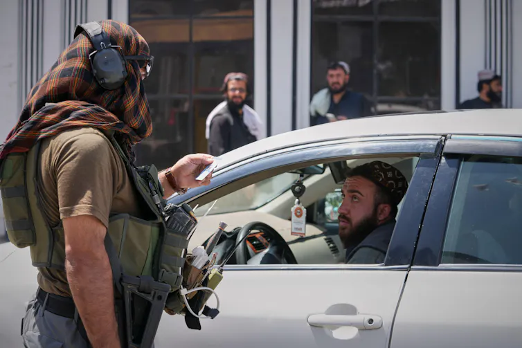 Afghan security forces check a driver's papers, Kabul, August 13 2026.