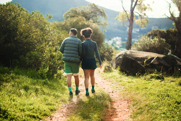 Two people walking on a country trail.