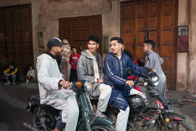 Tres jóvenes montados en motos mantienen una conversación