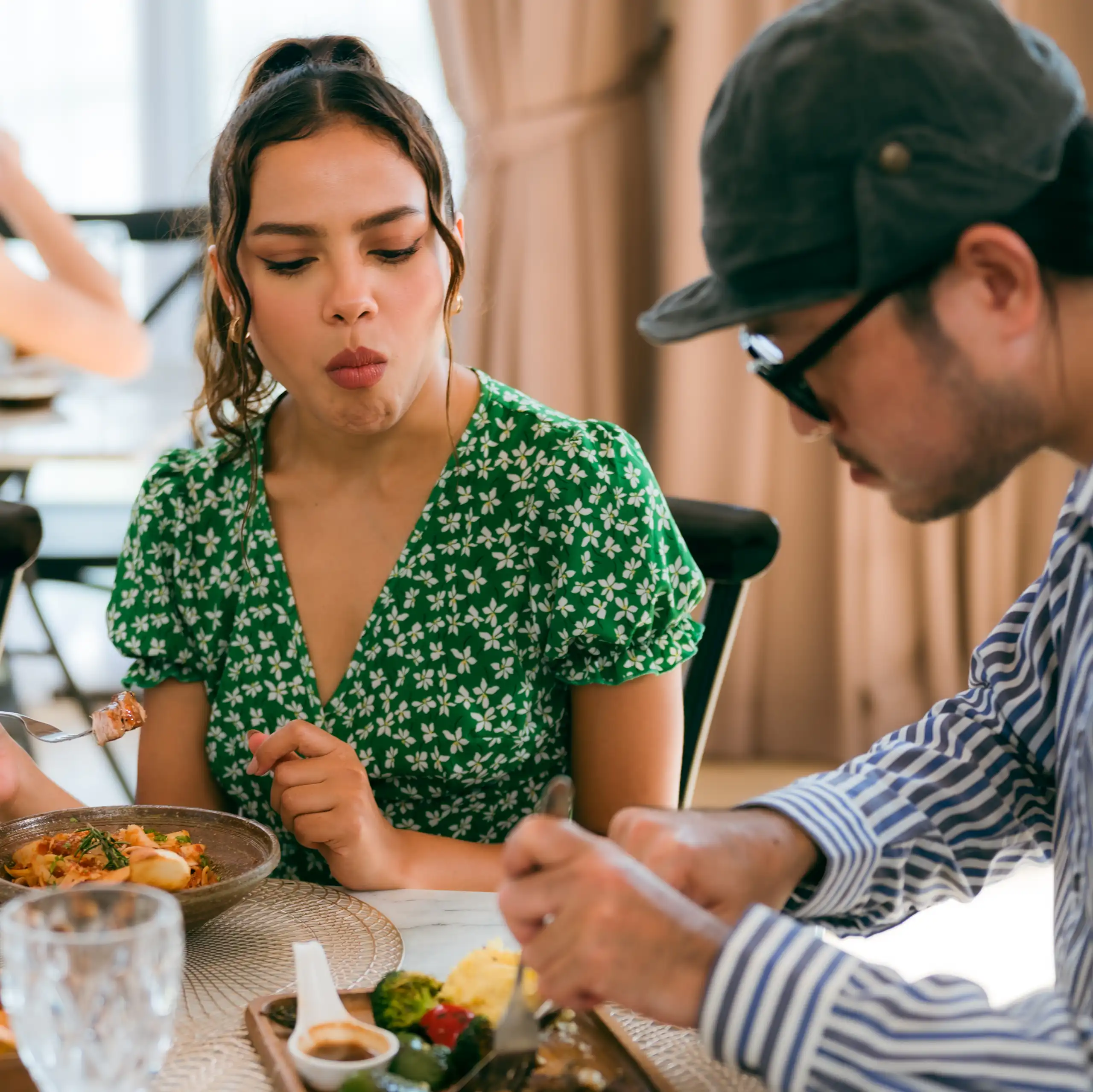 Photo d’une jeune femme en train de regarder son voisin au cours d’un repas