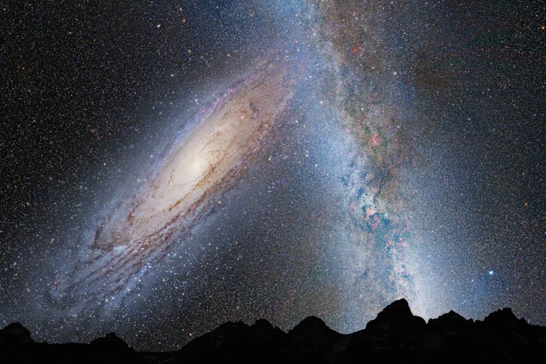 Two galaxies in the night sky, merging into one.