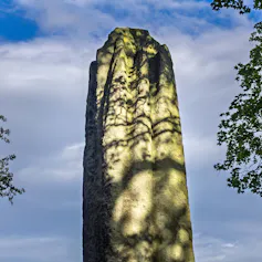 Close-up of a stone monolith in dappled sunlight.