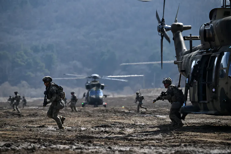 South Korean and US troops disembark from a military helicopter during a joint military exercise.