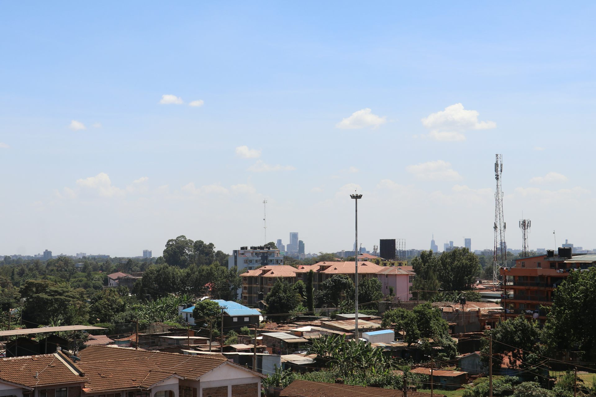 City skyline, with shacks in the foreground and tall buildings in the distance