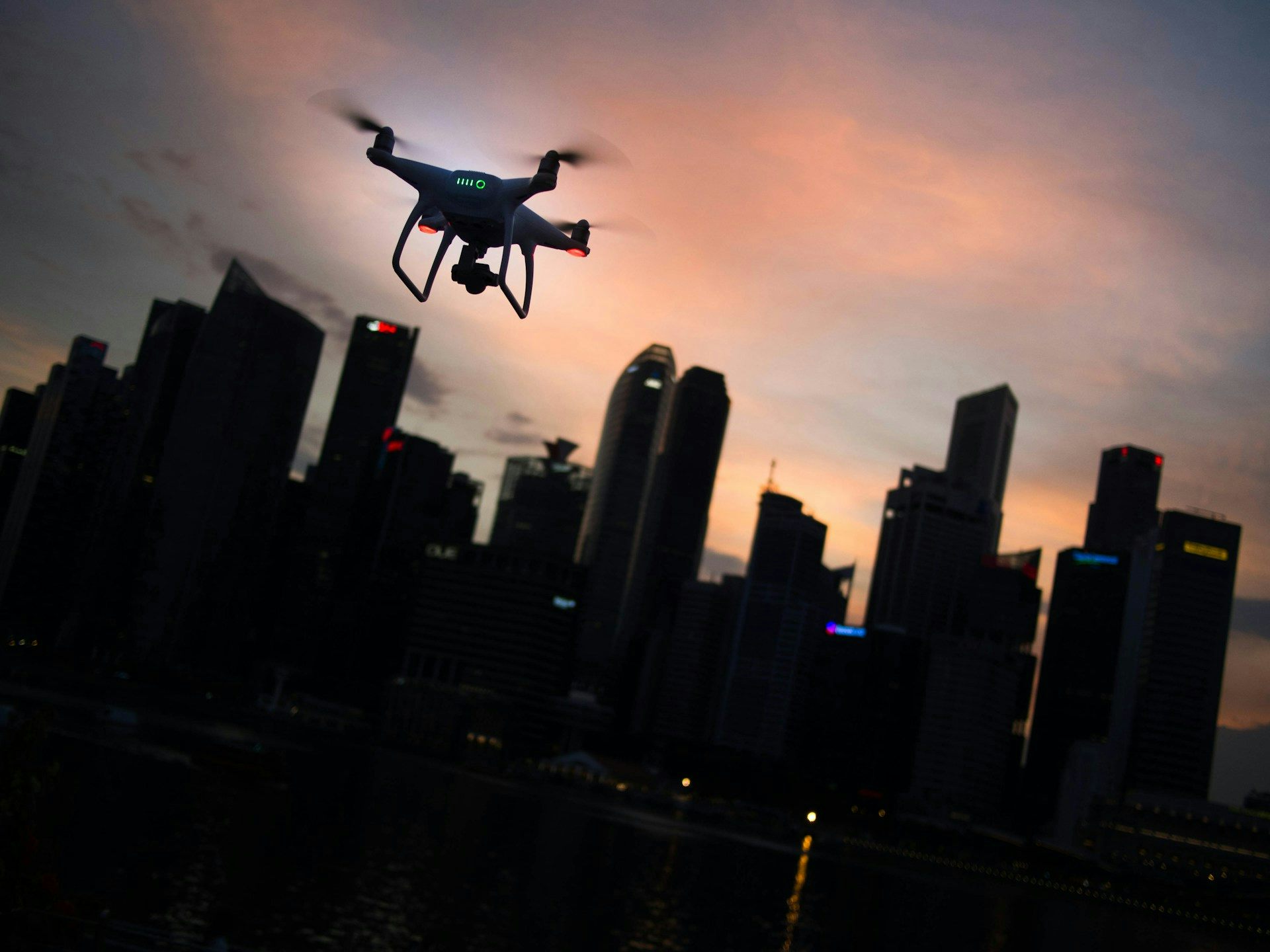 A quadcopter drone hovering near a city.