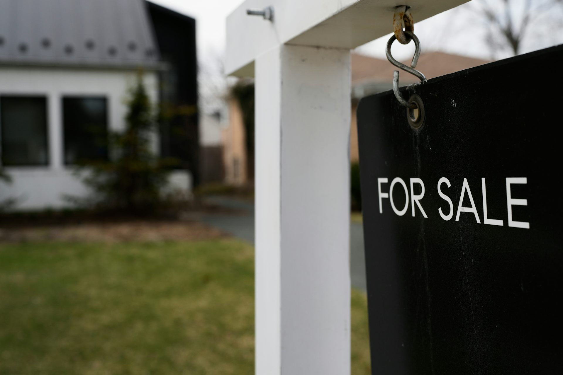 A House For Sale sign is displayed in front of a home