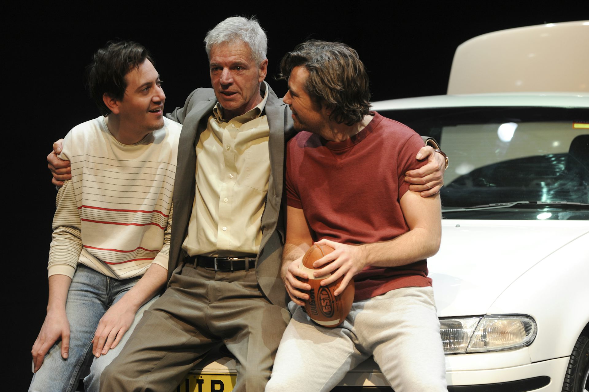 Production image: a dad and two kids on a car bonnet.