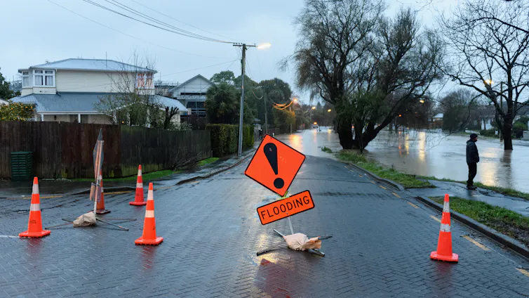 A flood warning sign as waters rise in a street