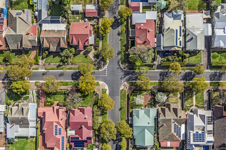 aerial view of suburb with streets and roof with solar panels.