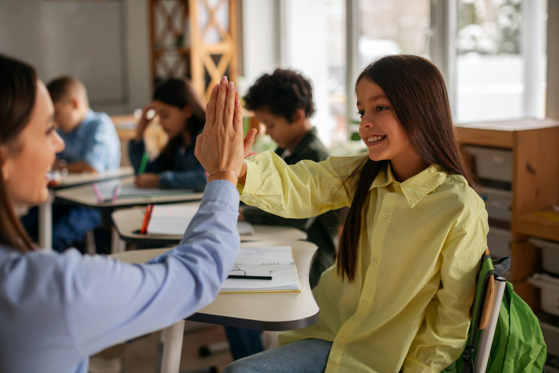 Una profesora "choca los cinco" con una alumna
