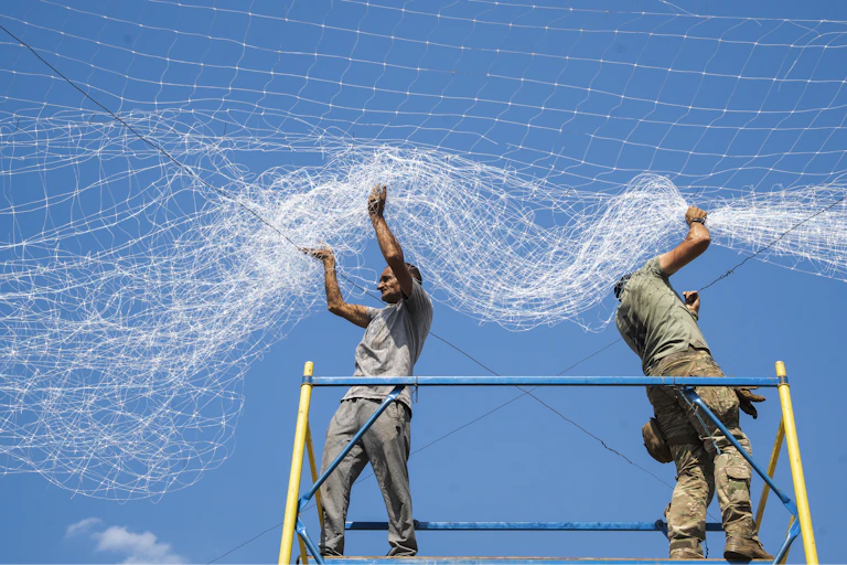 Ukrainian servicemen repair anti-drone nets damaged by Russian strikes in the city of Sloviansk.