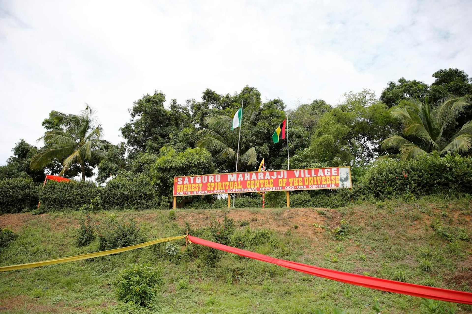 A lush green ridge of trees with a long billboard.