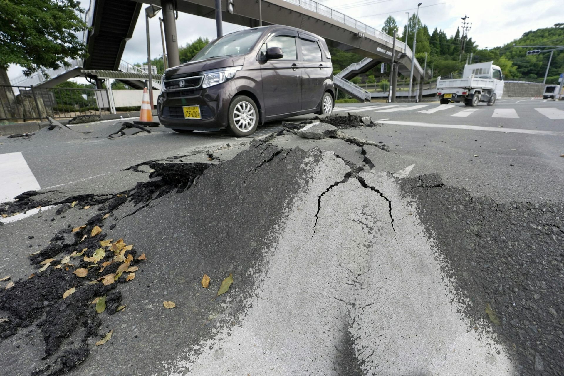 Uma estrada com rachaduras e alguns carros