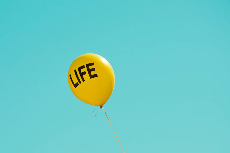 A yellow balloon reading LIFE in a clear blue sky