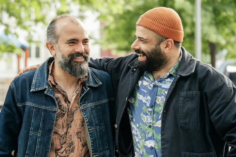 Two middle-aged men outside, laughing