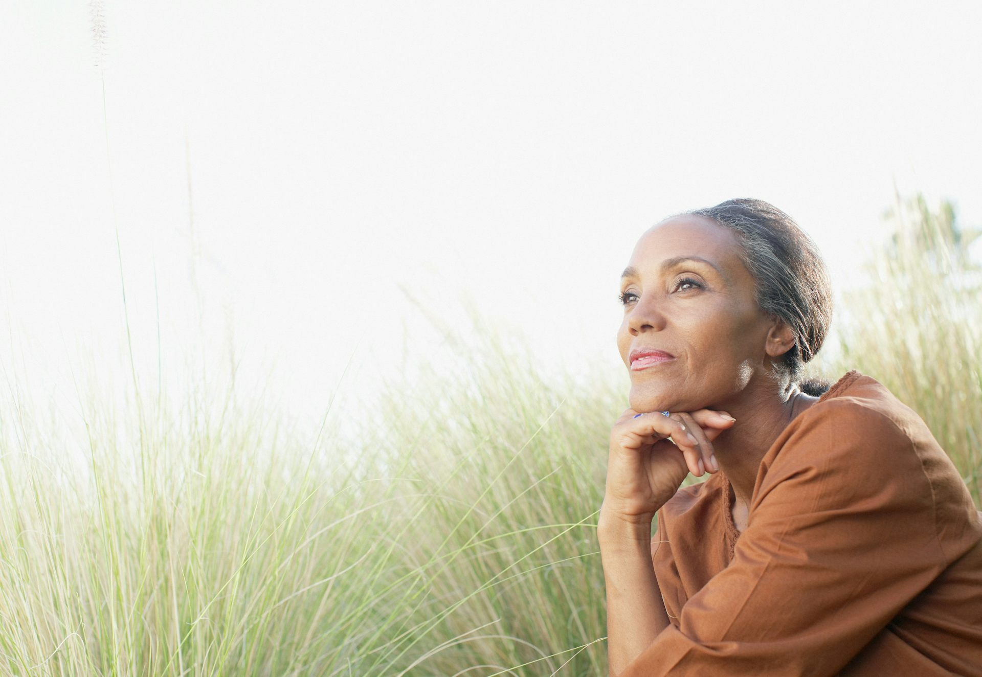 A woman with greying hair sitting outdoors