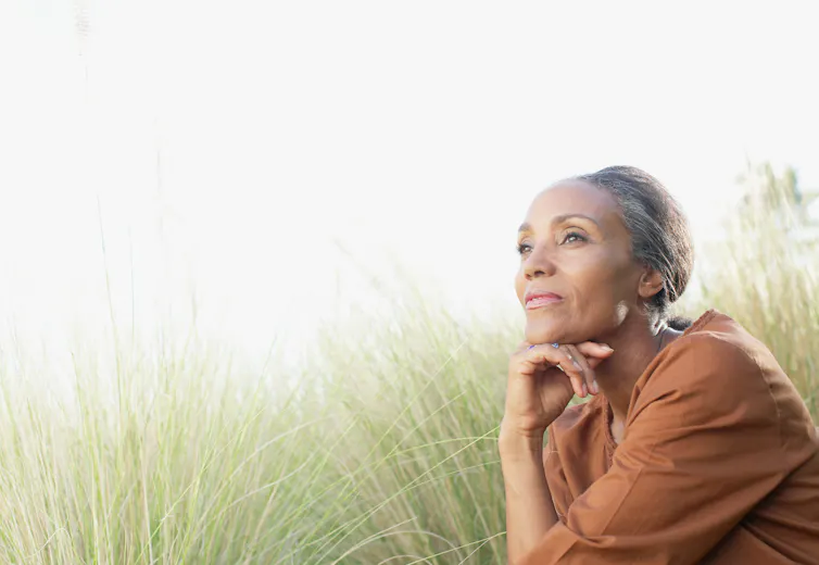 A woman with greying hair sitting outdoors