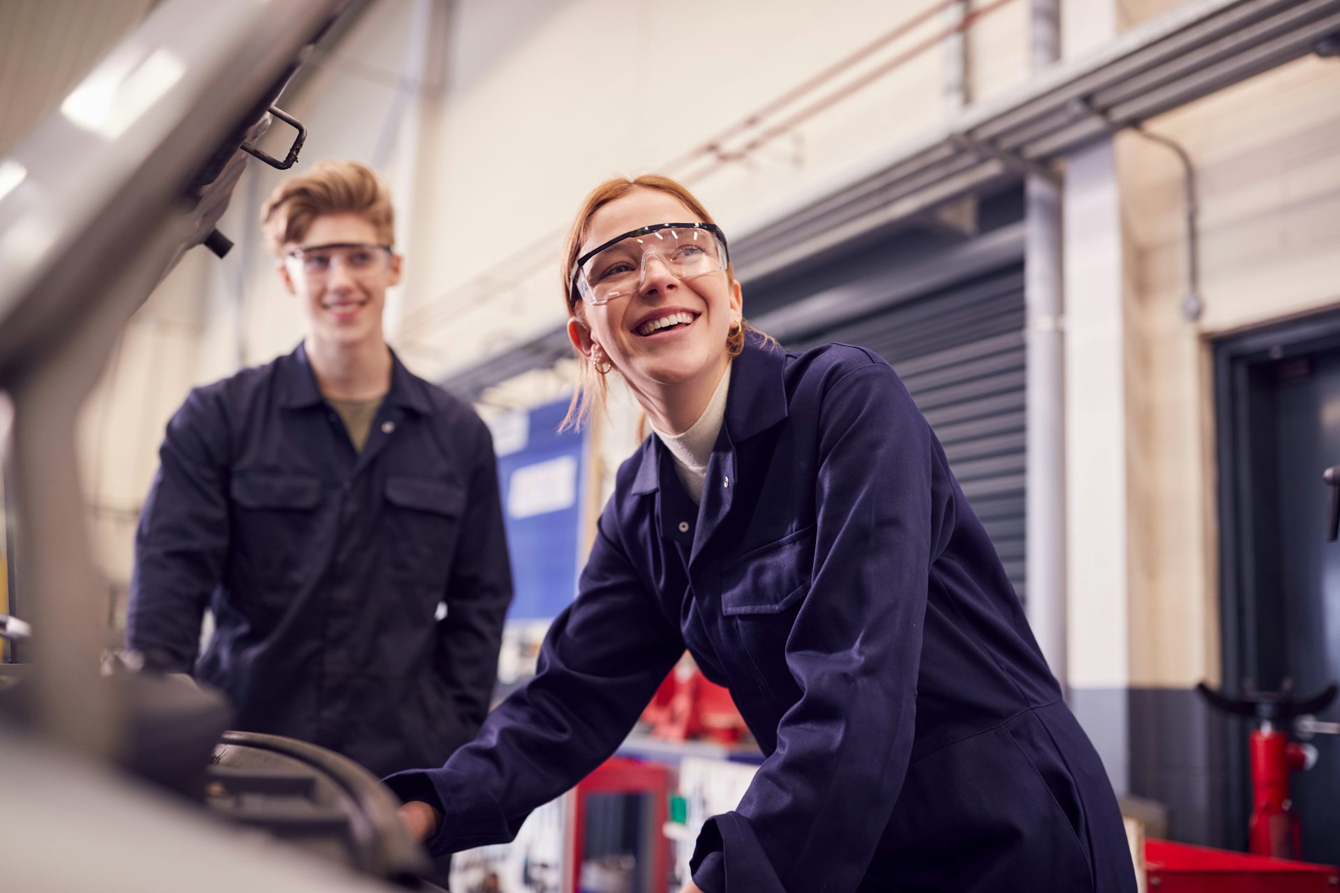 Young man and woman working on car