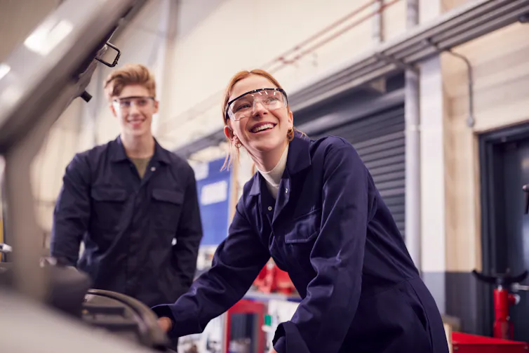 Young man and woman working on car