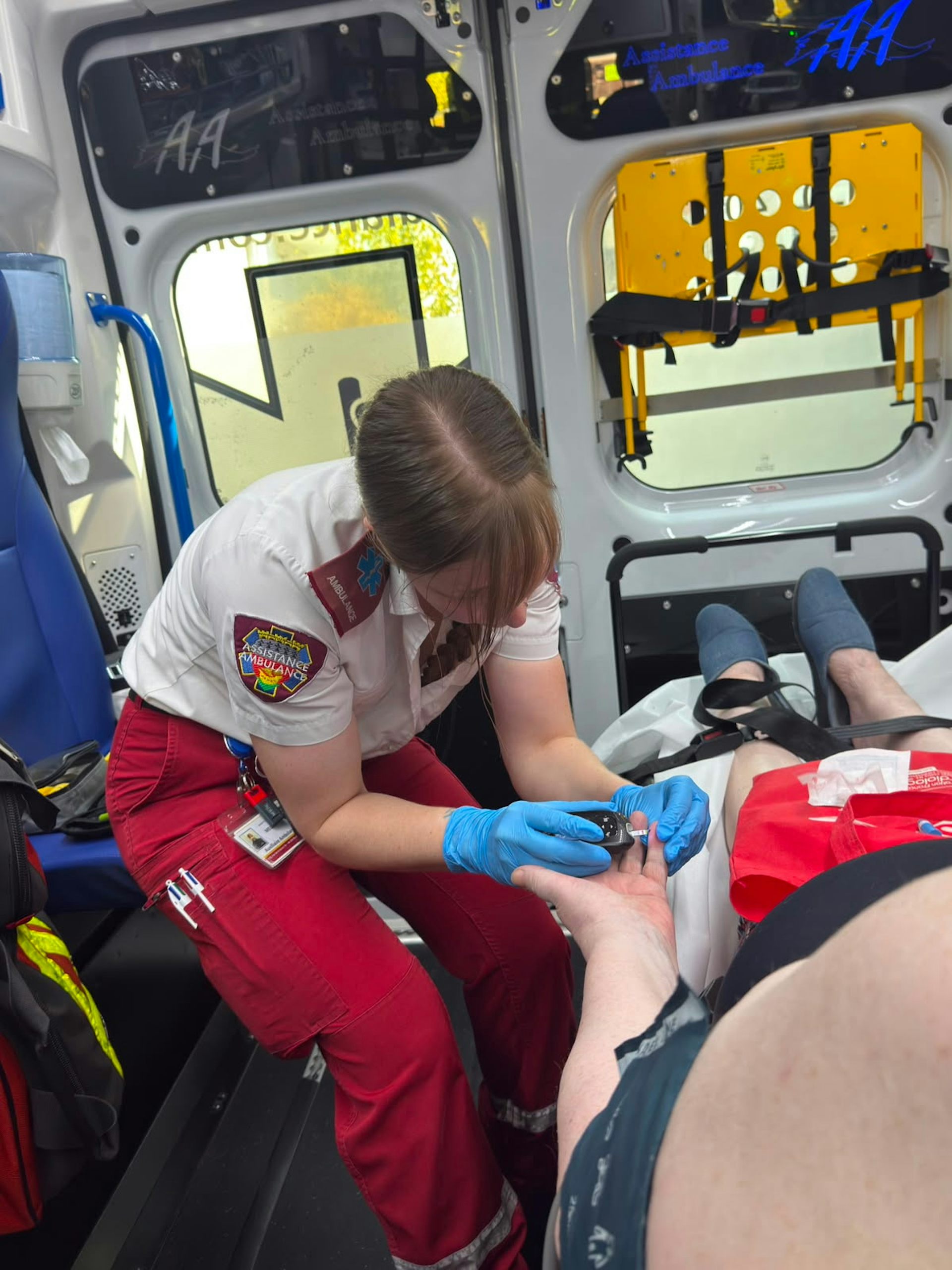 Une ambulancière prend en charge une personne malade dans une ambulance.