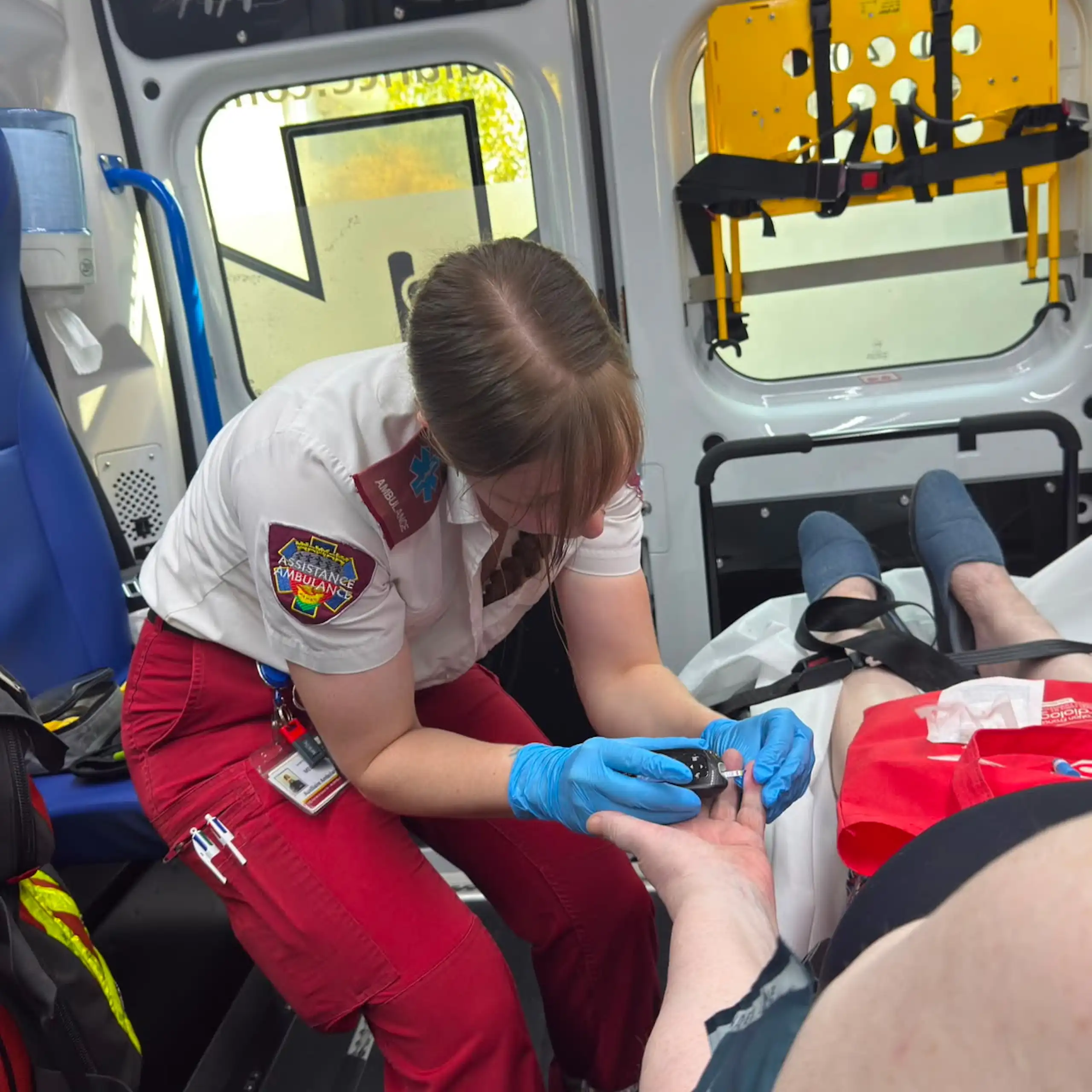 Une ambulancière prend en charge une personne malade dans une ambulance.