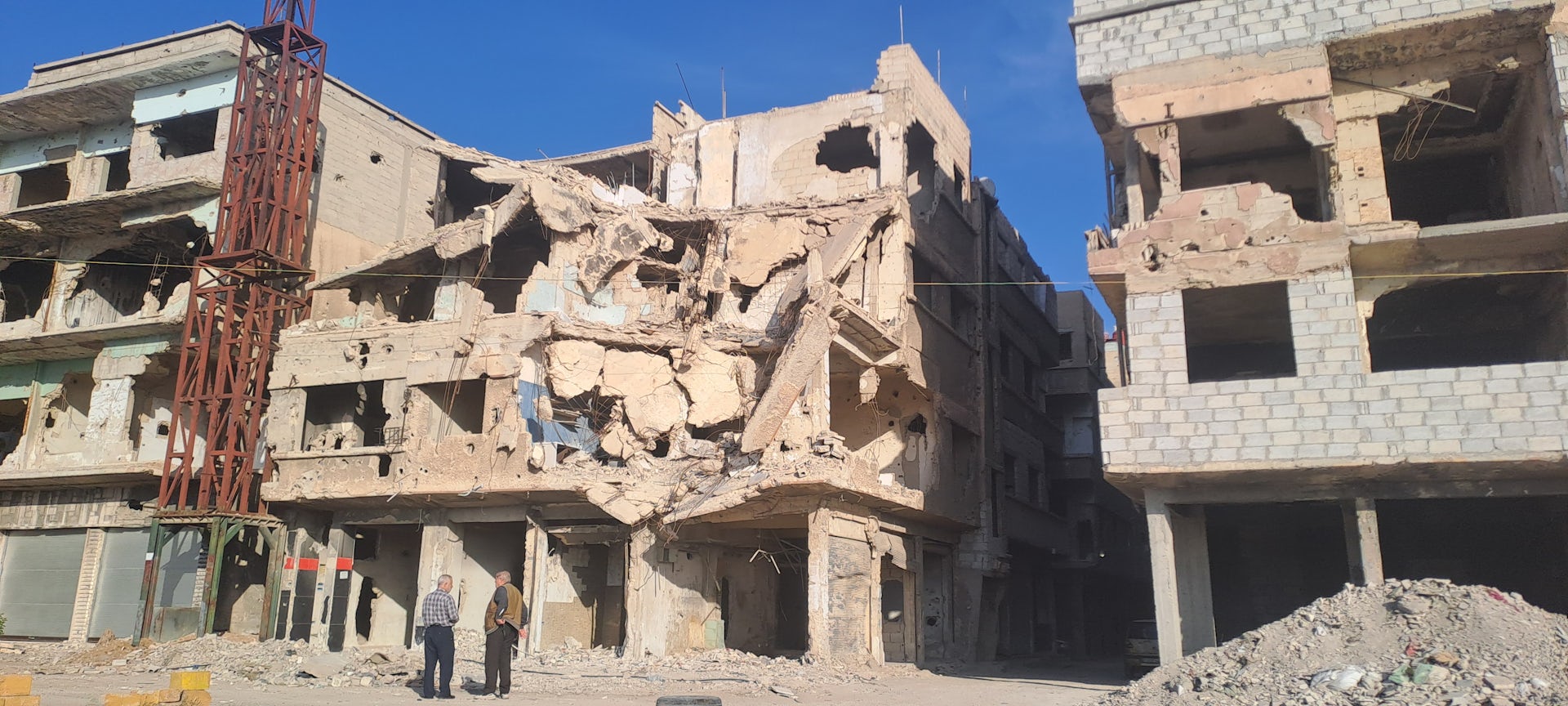 Men talking amid city ruins