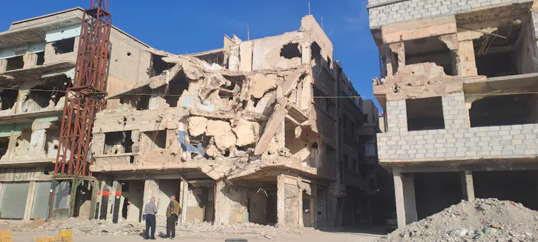Men talking amid city ruins