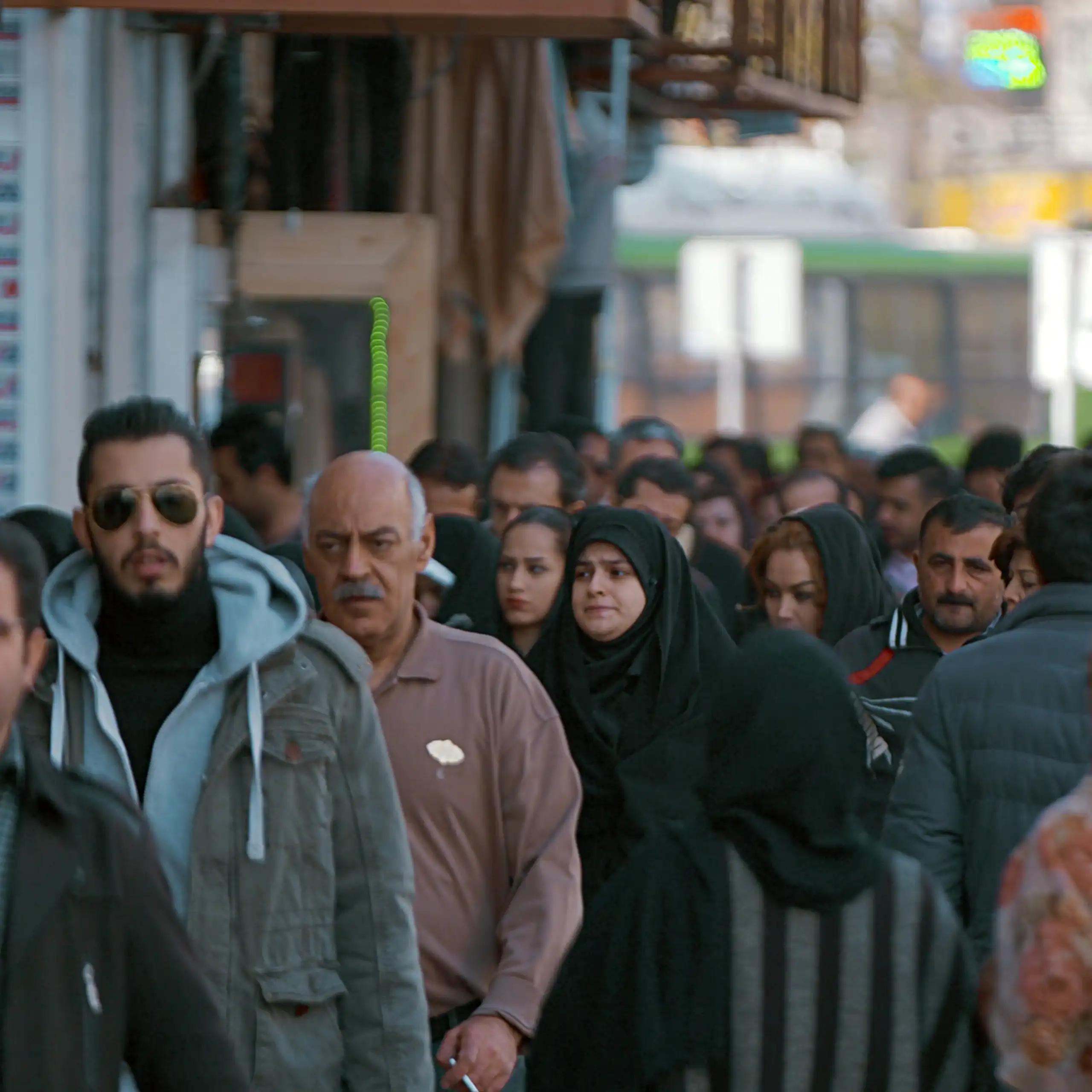 Pedestrians walk down a crowded street in Tehran, Iran.