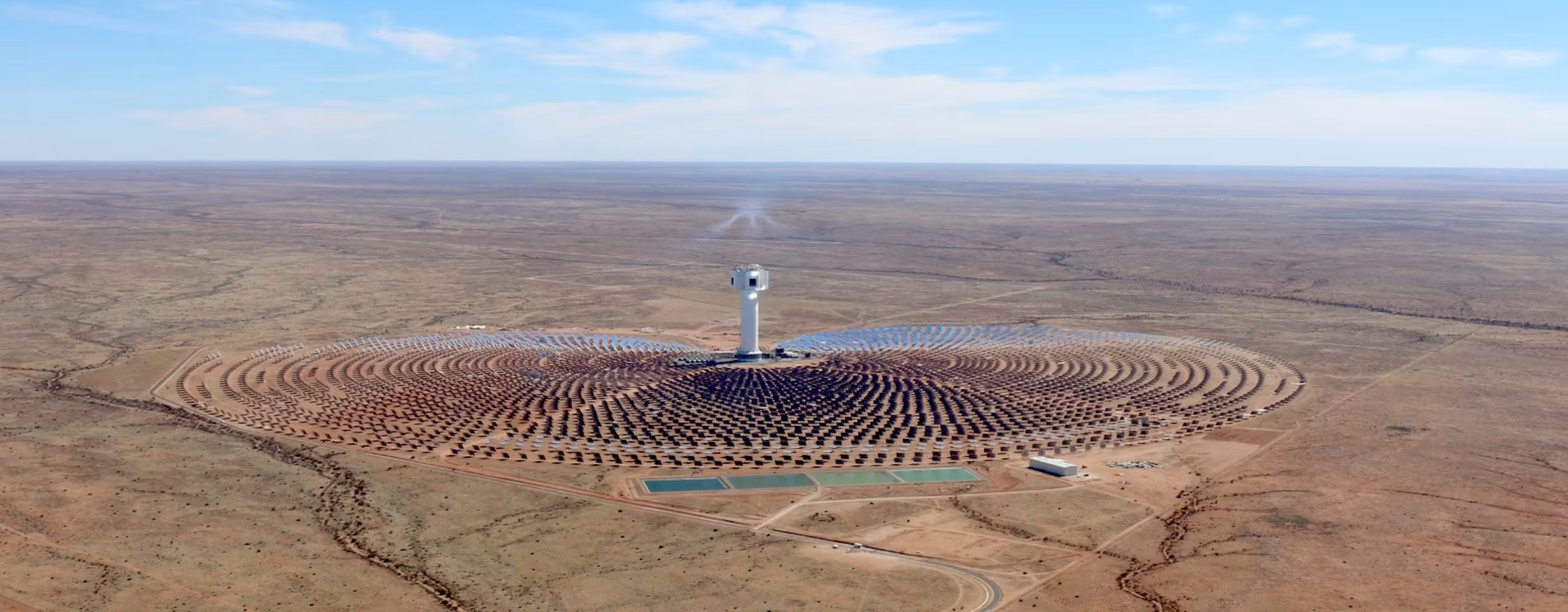 A concentrating solar plant in the middle of a desert - circles of solar panels around a massive central tower