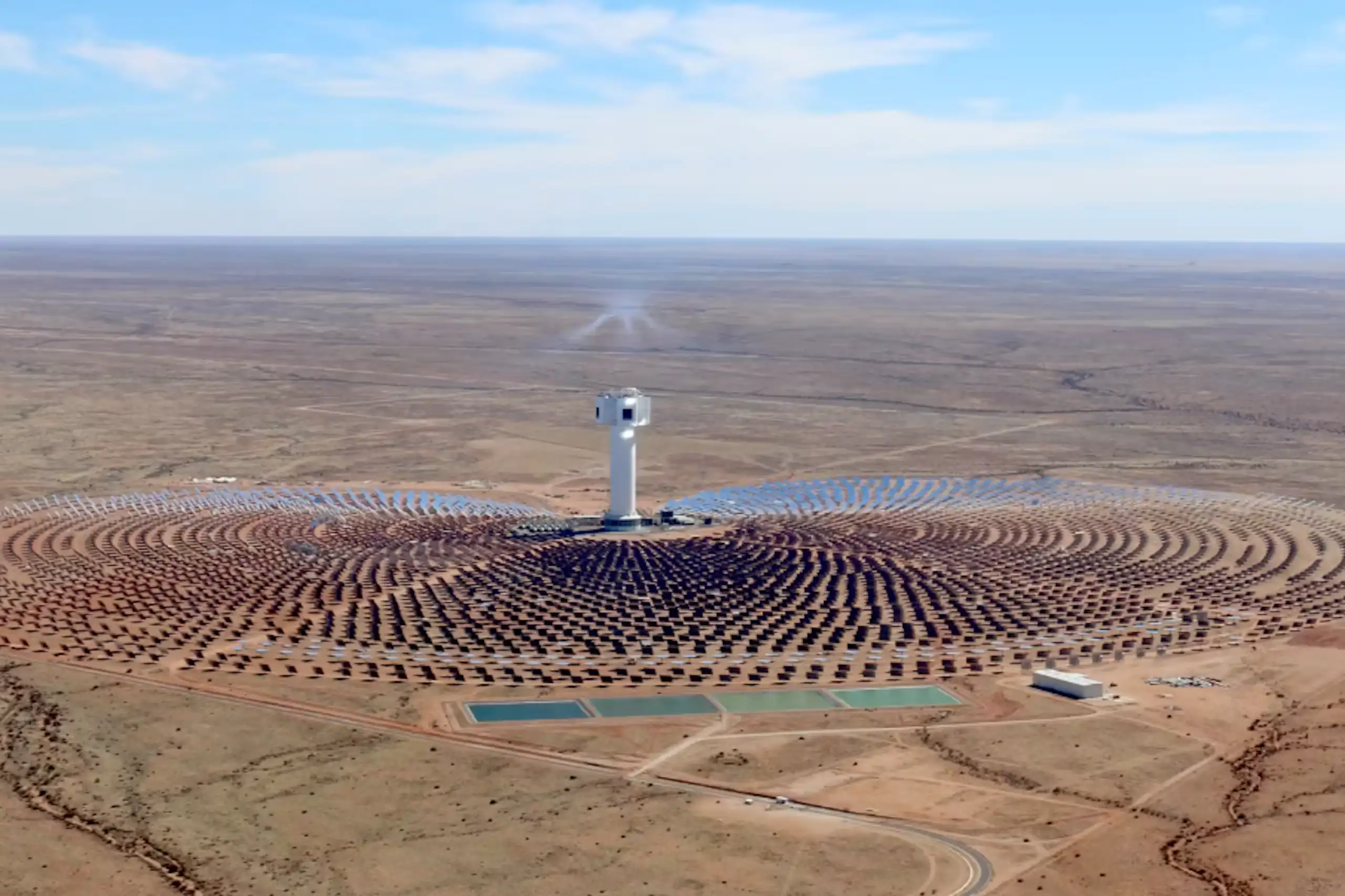 A concentrating solar plant in the middle of a desert - circles of solar panels around a massive central tower