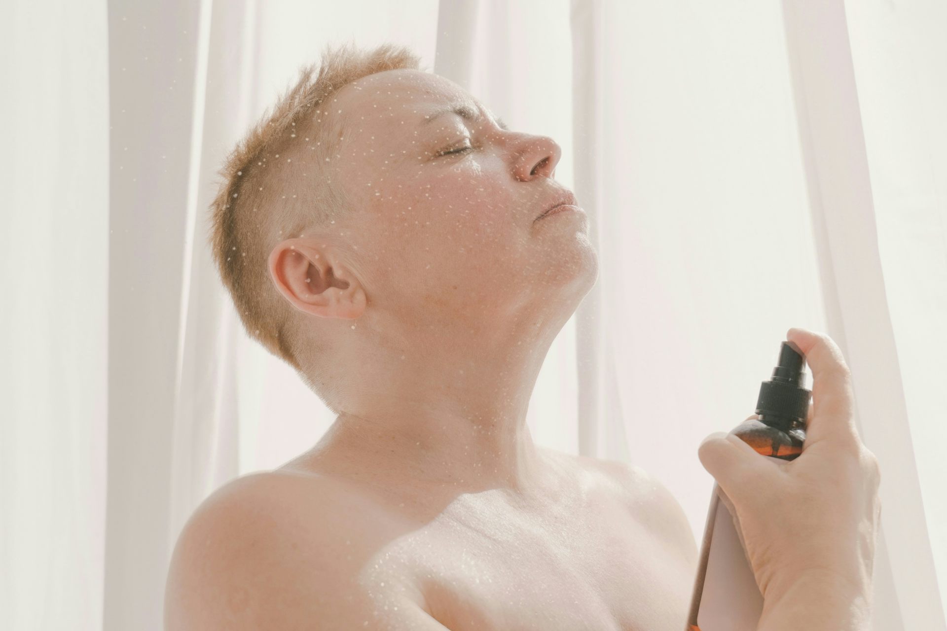 Un homme vaporise un parfum sur son cou