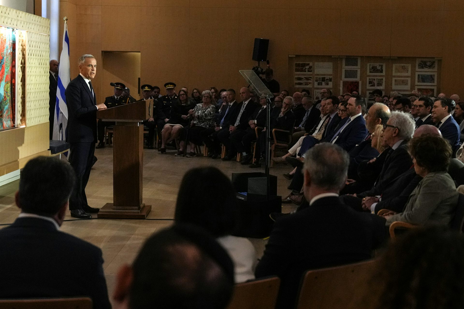 A man standing at a podium while delivering a speech to a room of people.