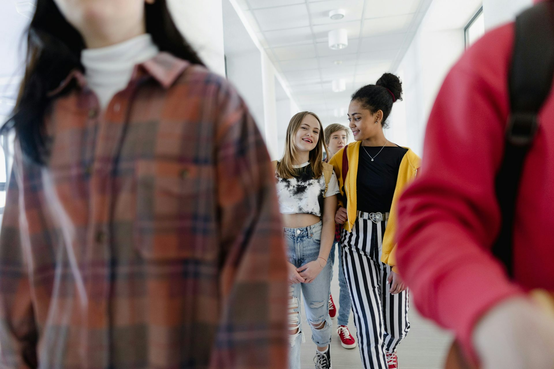 Two girls walk down a school hallway